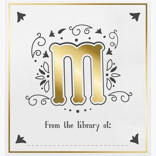 Decorative bookplate with gold letter 'm' and decorative elements on a white background.