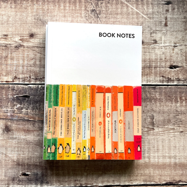 Notebook titled 'Book Notes' with a colorful book spine design on a wooden surface