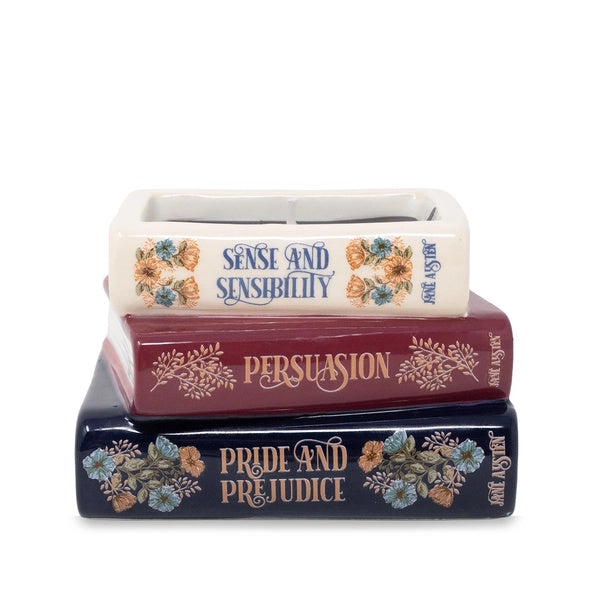 Stack of books candle with 'Sense and Sensibility', 'Persuasion', and 'Pride and Prejudice' on a white background
