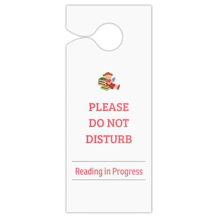 A white door hanger with a hole at the top, featuring a small illustration of a child reading books and the text 'PLEASE DO NOT DISTURB' and 'Reading in Progress' in pink on a white background.