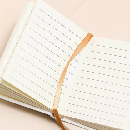 Open notebook with lined pages on a beige background